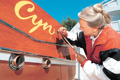 Judi Welch hand painting name on another boat